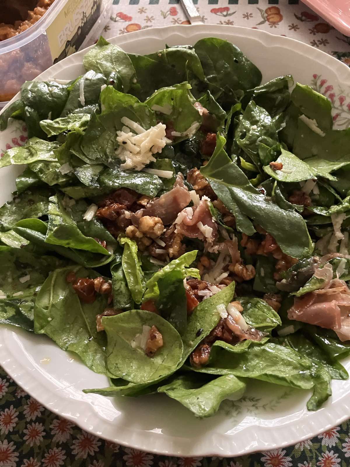 Spinach salad with dried tomatoes, parmesan, walnuts and prosciutto